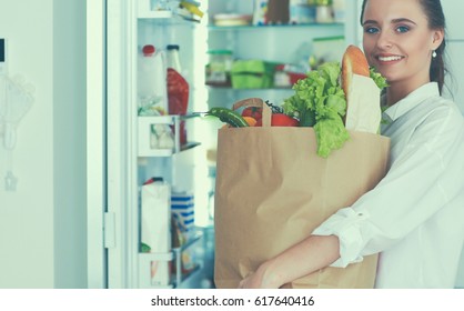 Young Woman Holding Grocery Shopping Bag With Vegetables .Standing In The Kitchen