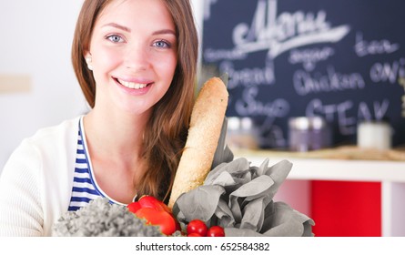 Young woman holding grocery shopping bag with vegetables - Shutterstock ID 652584382
