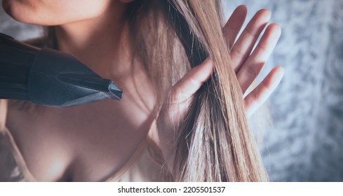 Young Woman Holding Hair Dryer