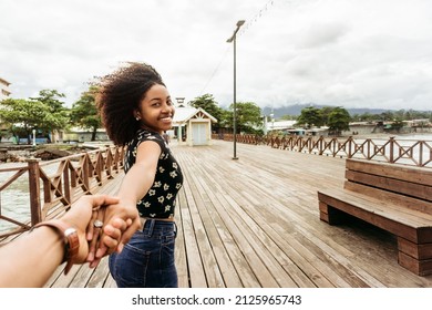 Young woman holding hand of her couple while hike in La Ceiba, Honduras.