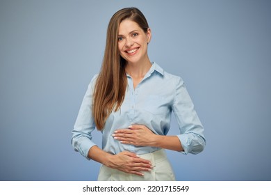 Young woman holding hands on stomach. isolated portrait. Happy girl on blue background. - Shutterstock ID 2201715549
