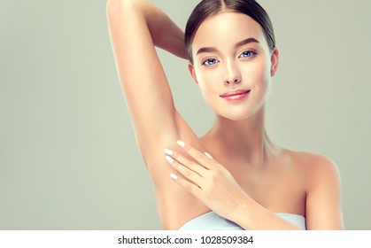 Young woman holding her arms up and showing underarms, armpit smooth clear skin .Girl showing clean armpit .Beauty portrait.Epilation and depilation of hair .  - Shutterstock ID 1028509384