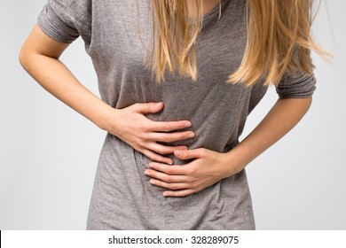 Young woman holding her stomach. She is having a menstruation pain.
