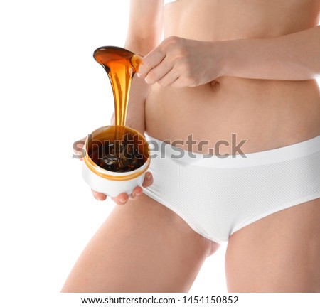 Young woman holding hot wax on white background, closeup. Epilation procedure