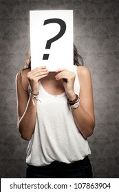 young woman holding interrogation symbol  in front of his face