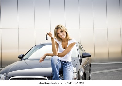 Young Woman Holding Keys To New Car And Smiling At Camera