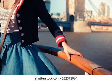 Young Woman Is Holding And Leaning Against The Rail On The Deck Of A Ship On A River Cruise