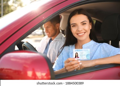 Young woman holding license while sitting in car with instructor. Driving school - Shutterstock ID 1884500389
