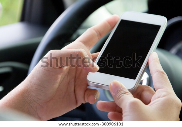 Young woman\
holding mobile device in the car\
