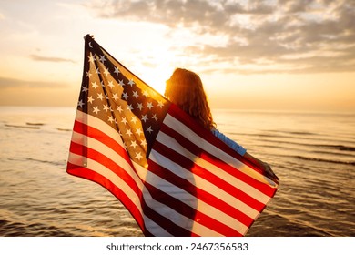  
Young woman holding national American flag cover ocean beach holiday travel at summer romantic sunset. America independence day concept. 4th of July. - Powered by Shutterstock