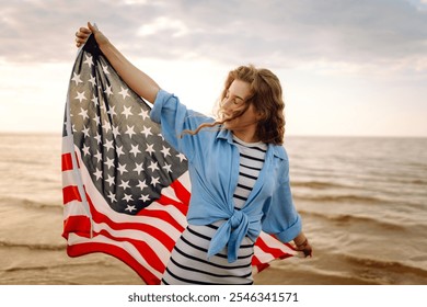 Young woman holding national American flag walking ocean beach. America Independence Day concept. 4th of July. - Powered by Shutterstock