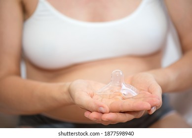 Young woman holding a nipple shield