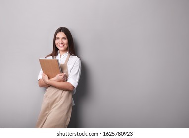 Young woman holding notebook i on  gray background. - Shutterstock ID 1625780923