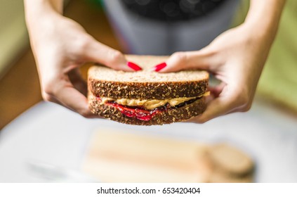 Young Woman Holding A Peanut Butter And Jelly Sandwich