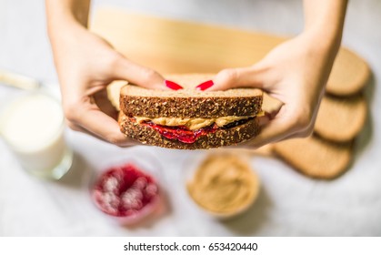 Young Woman Holding A Peanut Butter And Jelly Sandwich