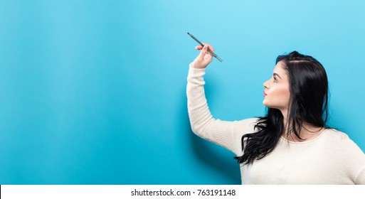 Young Woman Holding A Pen On A Solid Background