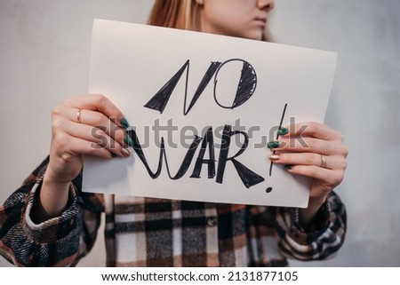 Young woman holding a placard protesting No to war. High quality photo