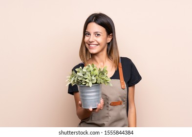 Young Woman Holding A Plant With Happy Expression