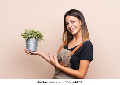 Young Woman Holding A Plant And Pointing It