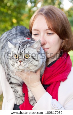 Young woman holding Scottish straight shorthair cat