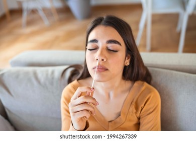 Young woman holding self testing self-administrated swab and medical tube for Coronavirus covid-19, before being self tested at home