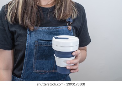 Young Woman Holding A Silicone Collapsible Cup, Reusable Coffee Tumbler.