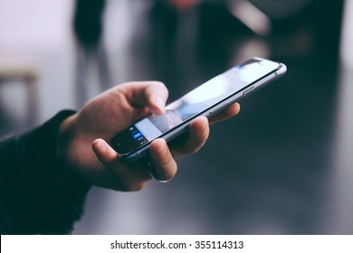 Young Woman Holding A Smart Phone, Side View