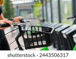 young woman holding smartphone using bike rental digital phone app scanning qr code to rent electric bicycle in city 