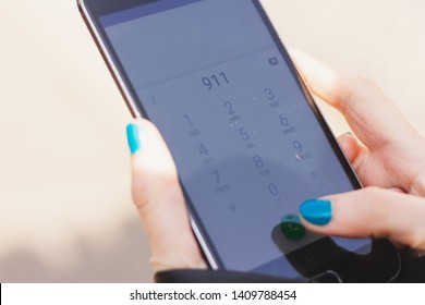 Young Woman Holding A Smartphone While Calling 911 – Person Dialing Emergency Service For Help