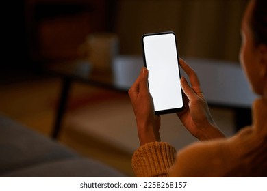 Young woman holding smartphone with white screen at home while relaxing in dark, copy space - Powered by Shutterstock