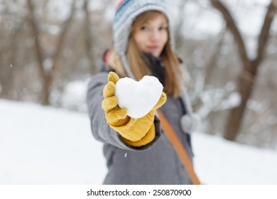 Young Woman Holding A Snow Heart In Hands. Saint Valentine's Day Concept