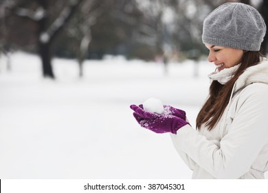 A Young Woman Holding A Snowball, Smiling