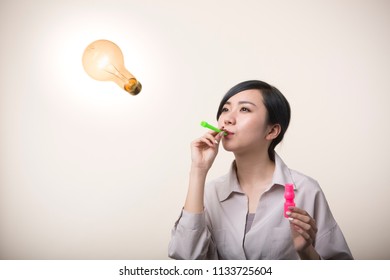 Young Woman Holding A Soap Bubble Straw In Mouth Blow Off A Light Bulb