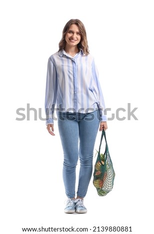 Young woman holding string bag with food and drink on white background