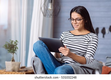 Young Woman Holding The Tablet And Sitting At Home