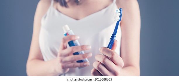 Young Woman Holding Toothpaste And Brush