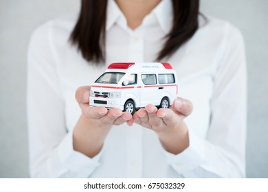 Young Woman Holding Toy Ambulance.