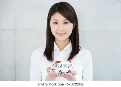 Young Woman Holding Toy Ambulance.