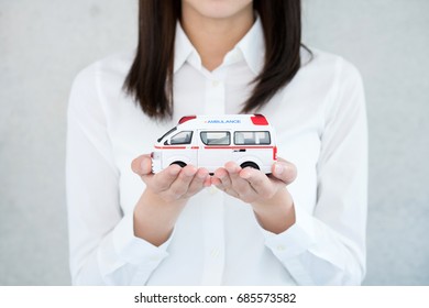 Young Woman Holding Toy Ambulance.