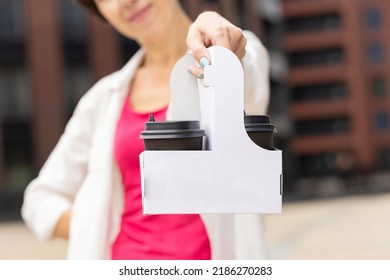 young woman holding two black craft paper cups with beverage in take away box. tea, cacao, coffee to go in holder. place for text, copy space