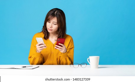 Young Woman Holding Two Smart Phones.