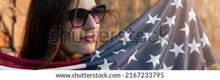 Young woman holding USA flag outdoors at sunset. Patriotic holiday. Independence day. Banner design