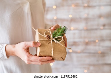 A young woman holding wrapped Christmas present.