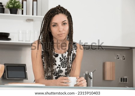 A young woman holds coffee in her kitchen, her expression reflects boredom and disappointment. A day full of difficulties, stress, and impolite people lies ahead Сток-фото © 