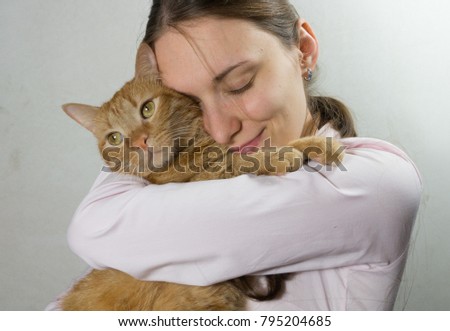 Young woman holds in hands of a cat