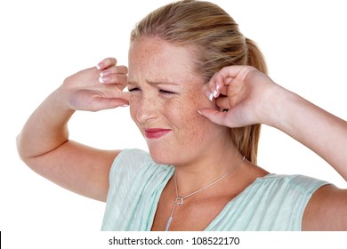 a young woman holds her fingers in her ears. loudness and tinnitus.,