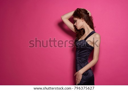    young woman holds her hair on a pink background                            