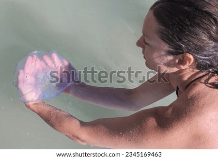 A young woman holds a jellyfish in her palms. About jellyfish - concept.