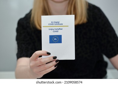 Young Woman Holds Printed EU Covid Certificate In Her Hand Close Up