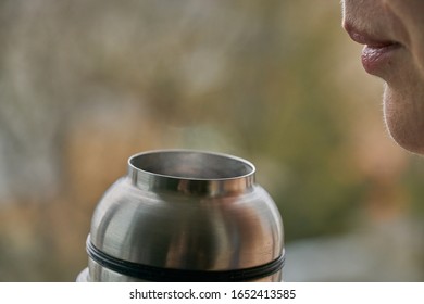 Young woman holds a thermos and drinks tea in autumn forest. - Shutterstock ID 1652413585